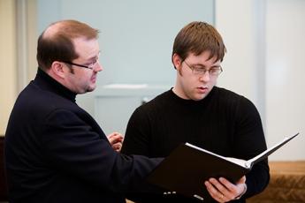 Student reviewing music score with professor