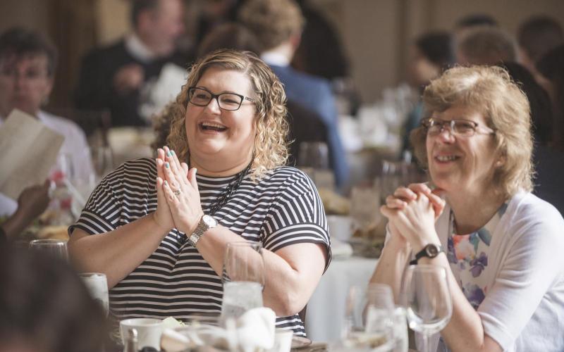 Laura Adam and Laurie Ongley enjoy the banquet slideshow