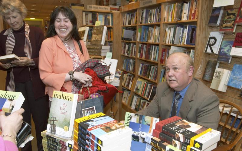 Here Michael Malone signs books.