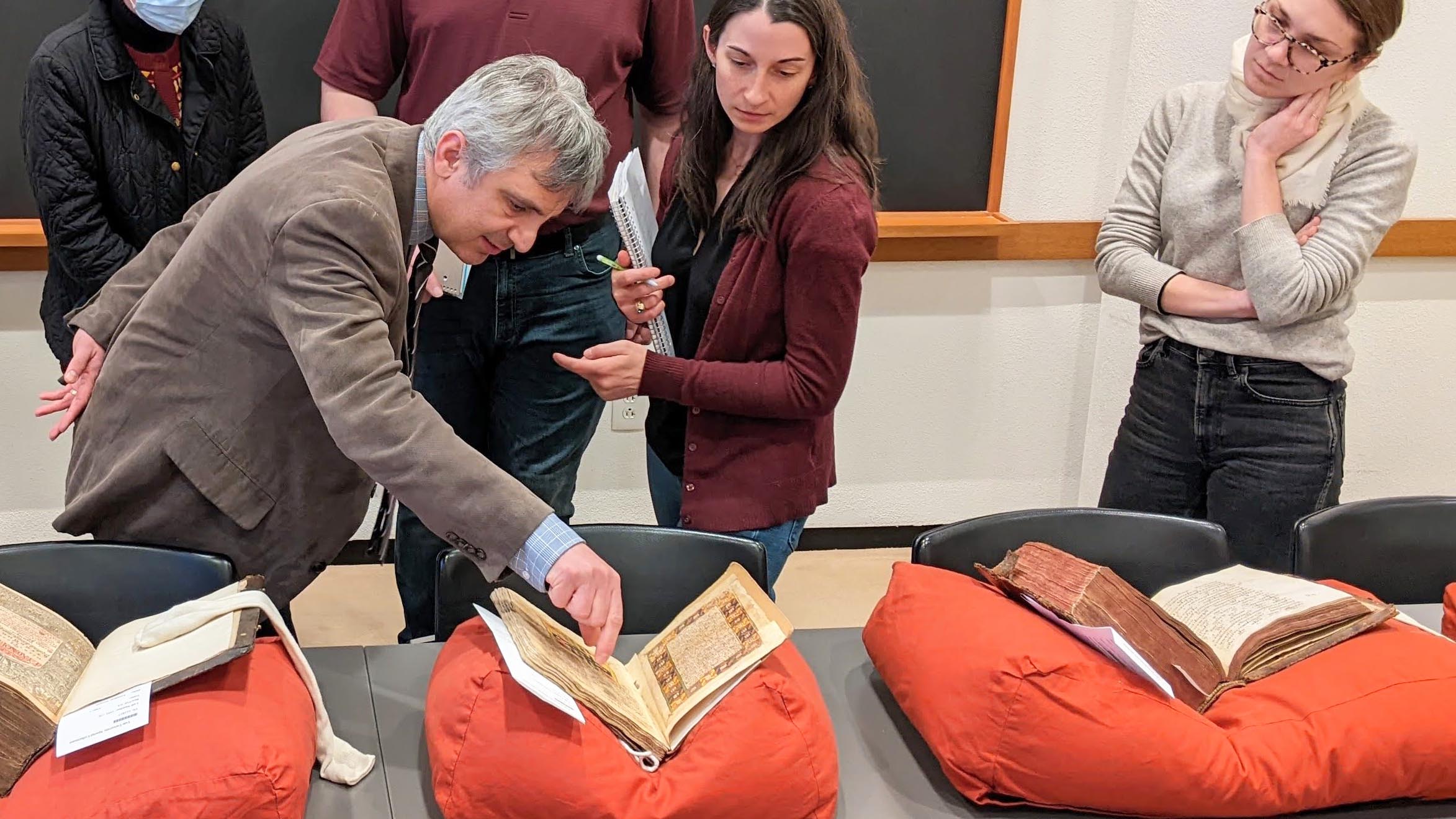 fellow and students looking at manuscript