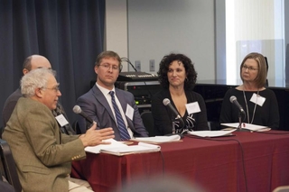 Panel of presenters at a table talking