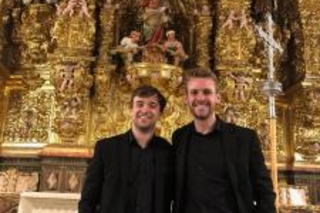 Schola singers Joseph Kemper and Charlie Littlewood pause in front of the Baroque altarpiece in Burgos Cathedral