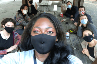 Students sitting at a picnic table with masks