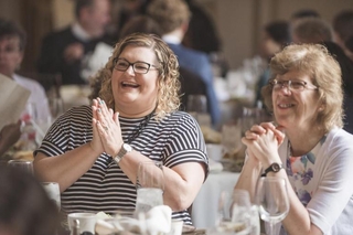 Laura Adam and Laurie Ongley enjoy the banquet slideshow