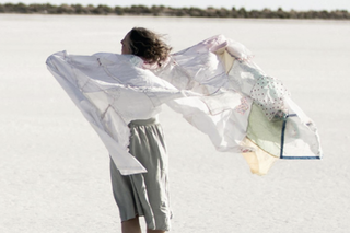 artist on the beach with a sheet in the wind