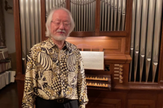 Masaaki Suzuki in front of an organ.