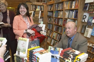 Here Michael Malone signs books.