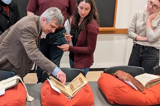 fellow and students looking at manuscript