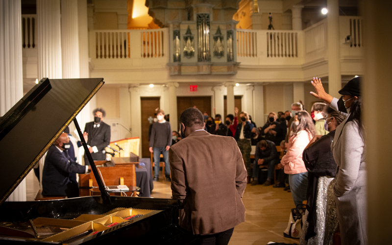 Derrick Jackson performs for Cornel West, Braxton Shelley, Cheryl Townsend-Gilkes, Nathaniel Gumbs, and a lively live audience